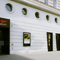 Fassade des Filmmuseums. Zu sehen ist die schwarze Eingangstür, einige Filmposter und runde Fenster