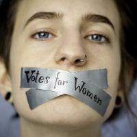 Foto einer jungen Frau, deren Mund zugeklebt ist. Auf dem Klebeband steht "Votes for Women" (Wahlrecht für Frauen)  Foto: Johanna Rauch