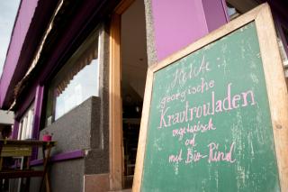 das Lokal Purple Eat. Vor dem Lokal steht eine Tafel, auf der das Tagesgericht angekündigt wird. Foto: Christopher Glanzl
